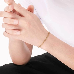 Gros plan d'un bracelet gourmette doré élégant porté au poignet pour un style moderne