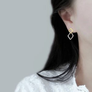 Minimalist rhombic drop earrings in gold and silver finish worn by a model