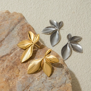 Detailed view of leaf-shaped stainless steel earrings in gold and silver finishes
