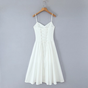 Détail de la robe mi-longue blanche avec un design à lacets croisés réglables au dos