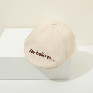 Close-up of baby beret hat with detailed Say Hello embroidery and breathable cotton texture