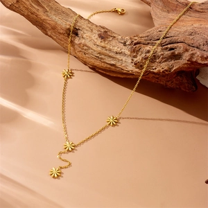 Elegante vergoldete Edelstahlkette mit Gänseblümchen-Anhängern auf rustikalem Holz