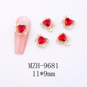 Detail of red heart nail charm with gold base and star accents for DIY manicure