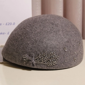 Detail of grey wool beret featuring elegant handcrafted rhinestone wheat ear embroidery