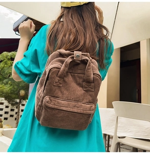 Rückansicht eines Models mit dem braunen Cord-Rucksack in einer hellen Außenumgebung