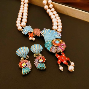 Macro view of ocean-style necklace with enamel sea shell and starfish charms
