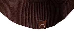 Macro view of dark brown rib-knit texture and original fashion tag on men's polo sweater