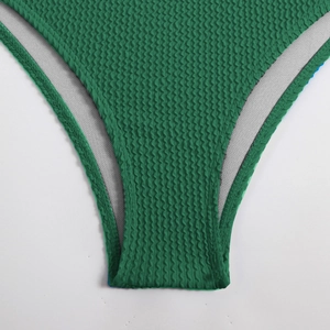 Macro shot of green waffle textured swimwear fabric with durable gray lining