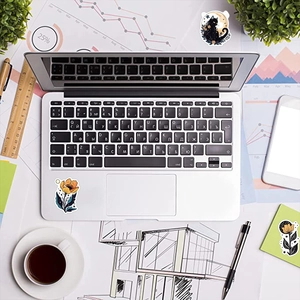 Flatlay of moon and floral cat stickers on a laptop and desk for DIY decoration
