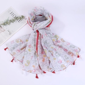 Detail of floral paisley print cotton linen scarf with soft red decorative tassels