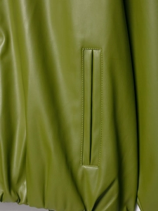 Makrodetail der Taschennaht und Ledertextur an einer grünen Vintage-Lederjacke