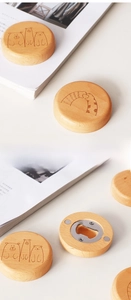 Macro shot of round beech wood bottle opener with cartoon bear and cat laser engraving