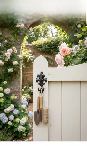 Vintage-Haken aus Gusseisen mit Lilien-Design an einem Gartentor aus Holz mit Schaufel