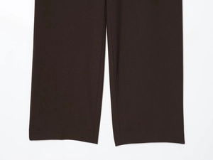 Detailed view of dark brown trousers hem with premium stitching and smooth texture