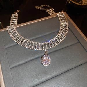 Gros plan du ras-du-cou argenté à franges avec cristal de zircon ovale central
