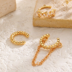 Detalle del conjunto de ear cuffs dorados con cadena y circón en piedra