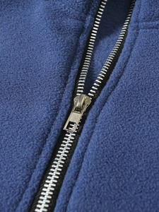 Close-up of silver metal zipper detail on blue fleece pullover jacket for men
