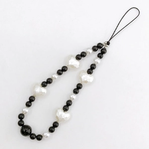 Detailed view of handmade phone strap with black and white acrylic heart-shaped beads
