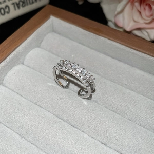 Macro shot of silver double-layered ring with inlaid zircons in a gray jewelry box