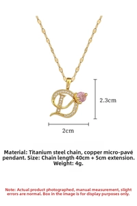 Detail of gold D-letter pendant with pink gemstone inlay and 40+5cm titanium steel chain