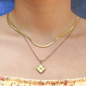 Detail of 18k gold plated double layered necklace with snake chain and flower pendant