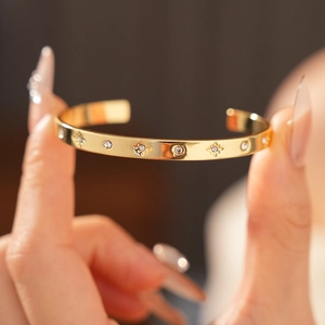 Gros plan du bracelet ouvert plaqué or avec motifs d'étoiles et zircons incrustés