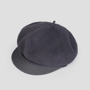 Détail d'un béret tricoté gris foncé montrant la texture fine et la visière courte