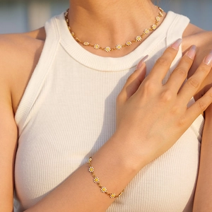 Conjunto de joyas de acero de titanio dorado con margaritas blancas en modelo
