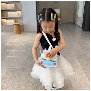 Bambina che indossa la borsa a tracolla unicorno arcobaleno con dettagli in peluche