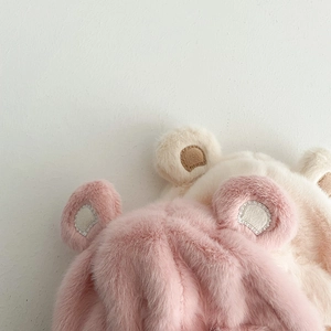 Dettaglio della morbida trama di peluche sui cappelli a forma di orso rosa e beige