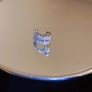 Macro shot of silver zircon ear cuff with marquise crystals on a gold mirror tray