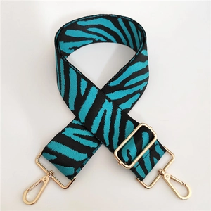 Close-up of zebra pattern wide strap in teal and black with gold adjustable buckles