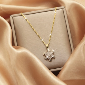 Macro detail of gold snowflake zircon pendant necklace placed on luxury silk in a jewelry box
