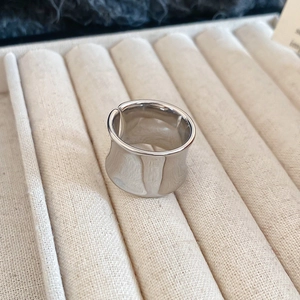 Macro view of adjustable silver polished metal wide-band ring in a jewelry box