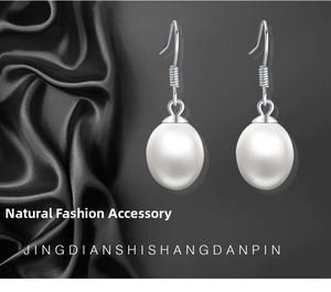 Detail of silver fish-hook earrings with natural drop-shaped white pearls