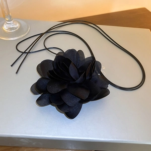 Detail of multi-layer black fabric flower necklace with elegant long thin rope design