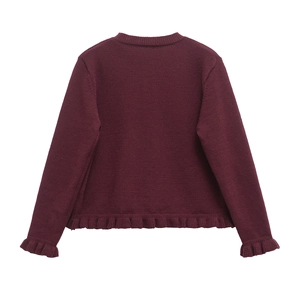 Detailed back view of a burgundy knit sweater featuring elegant ruffled hem and sleeve cuffs