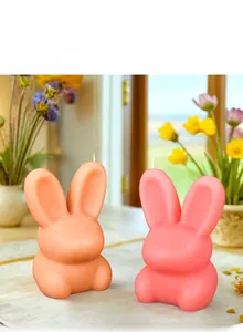 Makroansicht süßer Kaninchen-Duftkerzen in Pastellrosa und Orange für Ostern