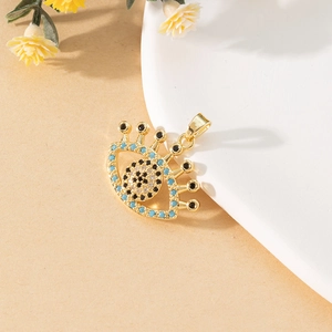 Macro detail of gold-plated evil eye pendant with turquoise beads and inlaid crystals