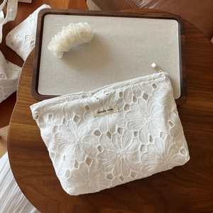 Detailed view of white cotton lace tote bag with floral embroidery and simple wish label