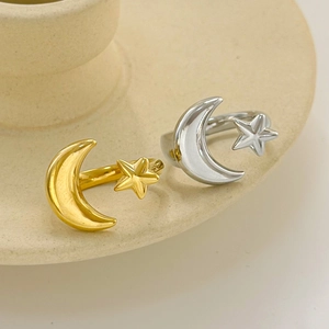 Minimalist moon and star open rings in gold and silver finish on ceramic tray