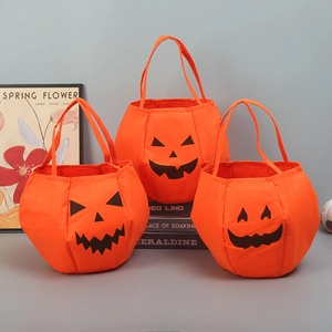 Three orange felt pumpkin candy bags with Jack-o'-lantern faces for Halloween decor
