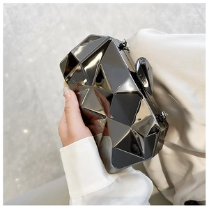 Close-up of a geometric acrylic clutch bag with a mirror-like gunmetal finish and chain