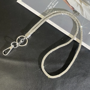 Close-up of sparkling silver rhinestone lanyard with metal lobster clasp on black leather