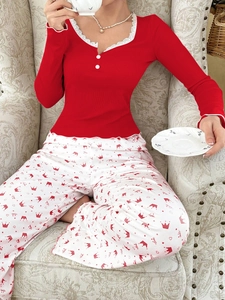 Detail of red ribbed long sleeve top with lace V-neckline and decorative white buttons