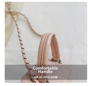 Detail shot of pink quilted mini bag handle and metal chain shoulder strap attachment