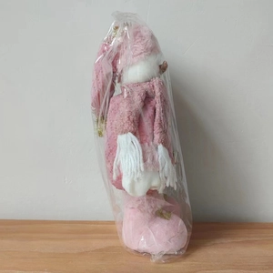 Detailed view of a pink Christmas snowman plush doll in protective plastic packaging