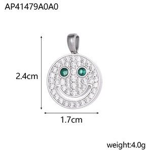 Detail view of smiley face pendant with white zircons, green gem eyes, and measurements
