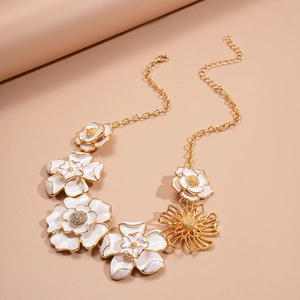 Detailed close-up of white 3D floral pendant necklace with gold trim and crystal accents