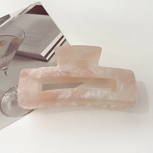Close-up of pink marble pattern acetate hair claw clip with shimmering glitter finish